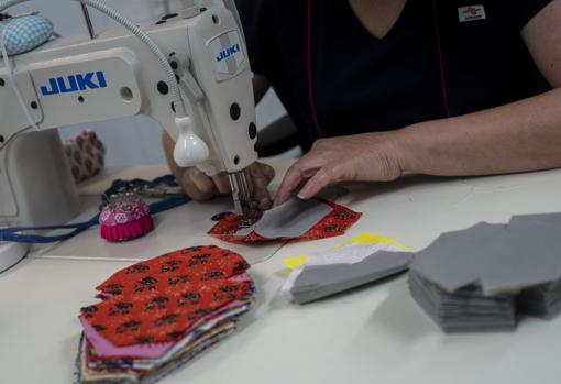 Una de las mujeres de Apramp confeccionando mascarillas