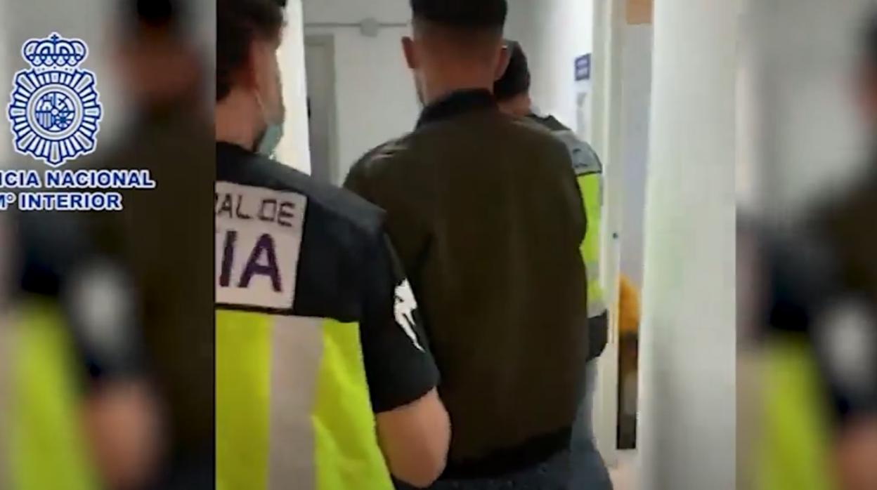 Uno de los detenidos es conducido por agentes de la Policía Nacional