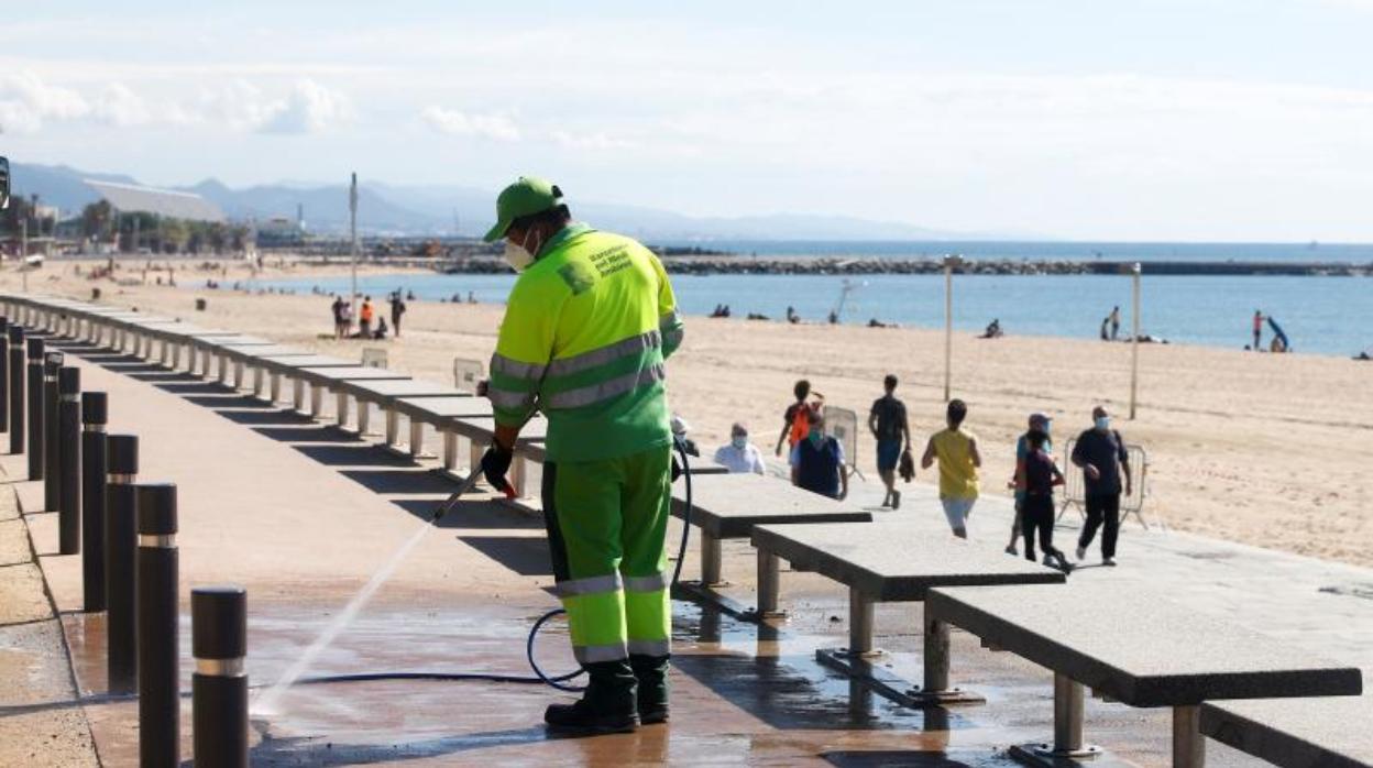 Un operario trabaja en la puesta a punto de la zona litoral de Barcelona, este martes