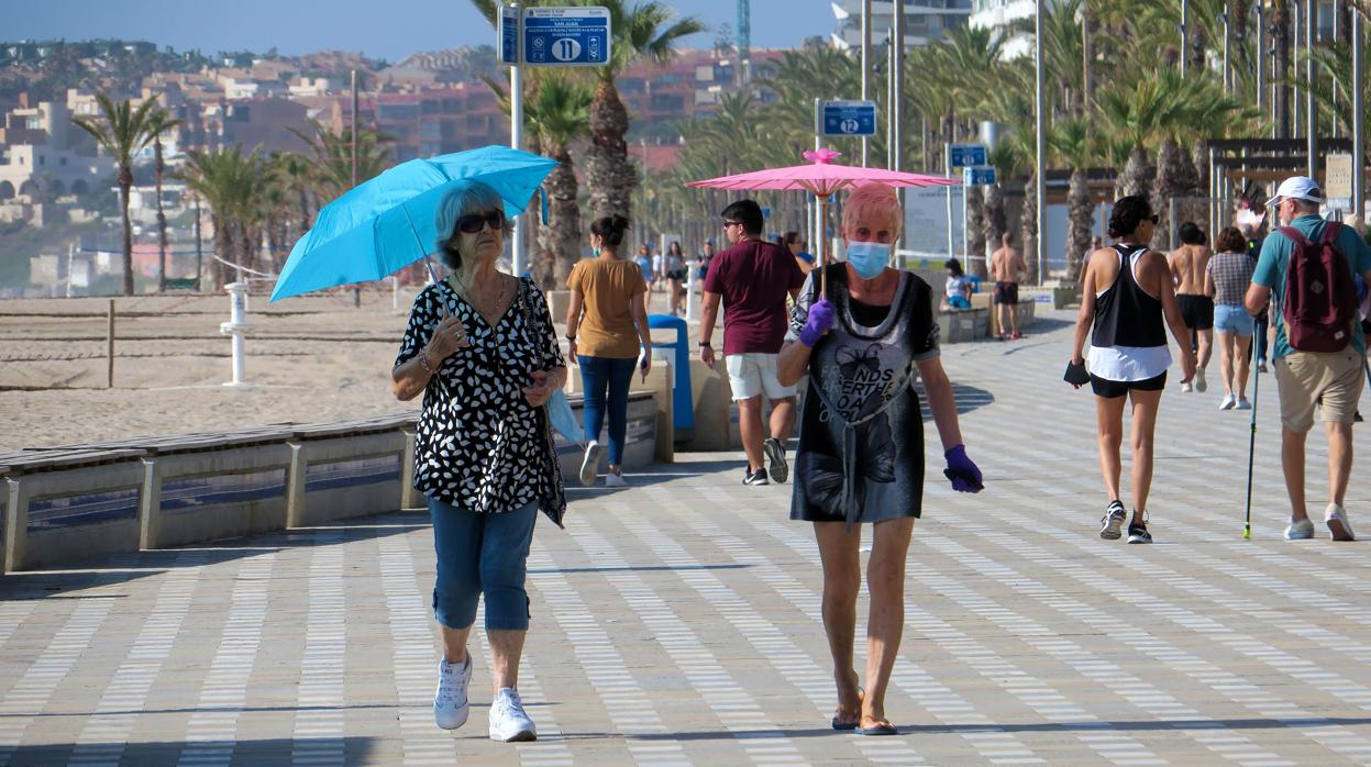 Varias personas pasean por la playa de San Juan de Alicante