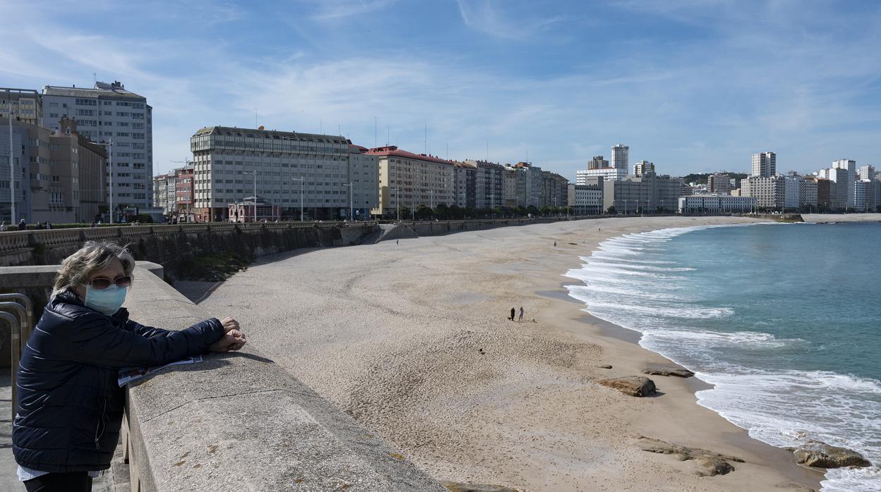 Mujer paseando en la playa de Orzán (La Coruña)