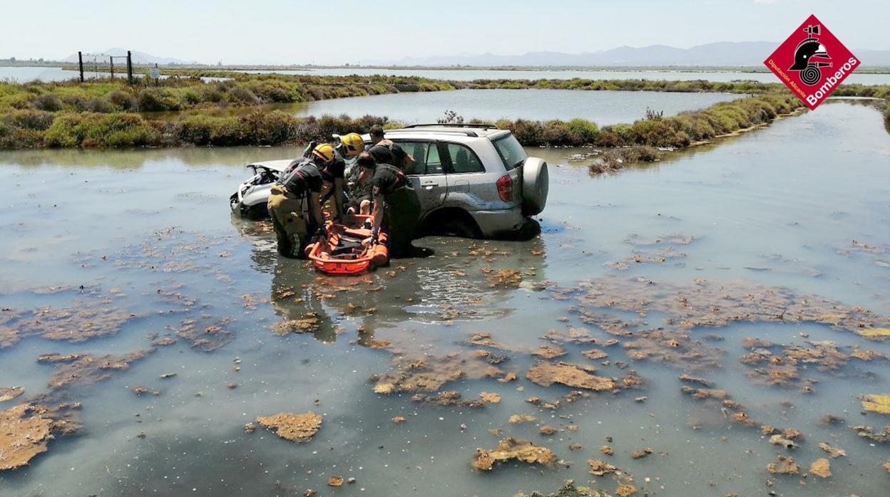 Efectivos de Bomberos rescatando a la conductora herida en la laguna