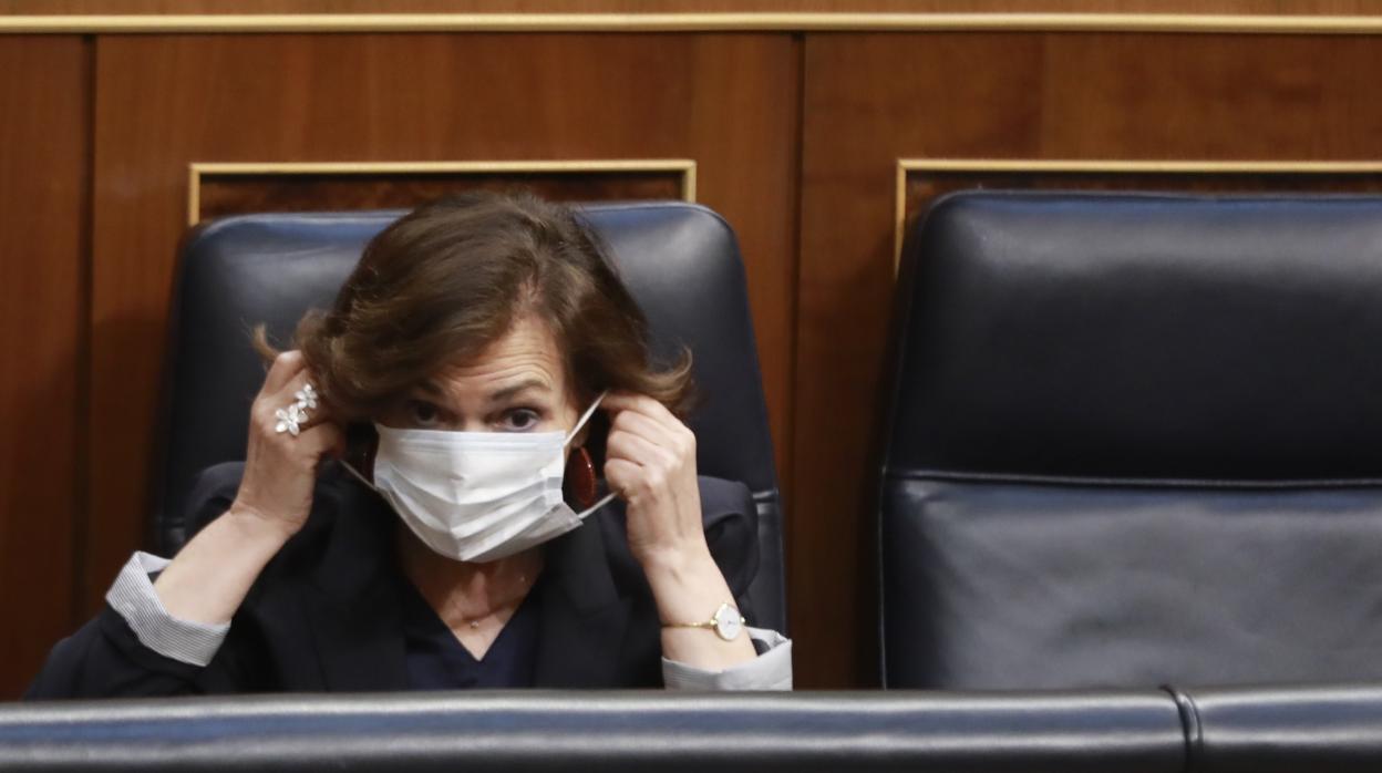 La vicepresidenta primera del Gobierno, Carmen Calvo, se coloca la mascarilla durante la sesión plenaria de control al Gobierno en el Congreso