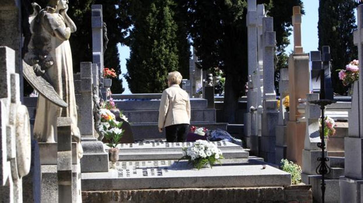 Una mujer visita a un familiar en un cementerio