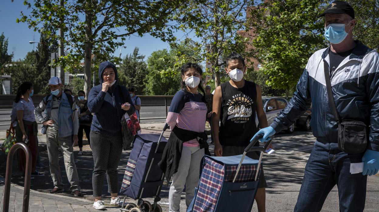 Cola de personas para recoger alimentos en un comedor social de Madrid