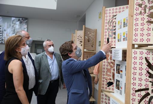 El alcalde, José Luis Marttínez-Almeida, junto a la delegada de Turismo, Almudena Maíllo, se descarga un folleto en la oficina de turismo de la Plaza Mayor, premiada con el sello de turismo seguro