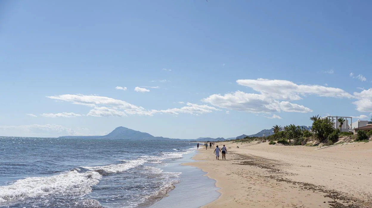 Imagen de unas personas paseando por la playa de la localidad valenciana de Oliva