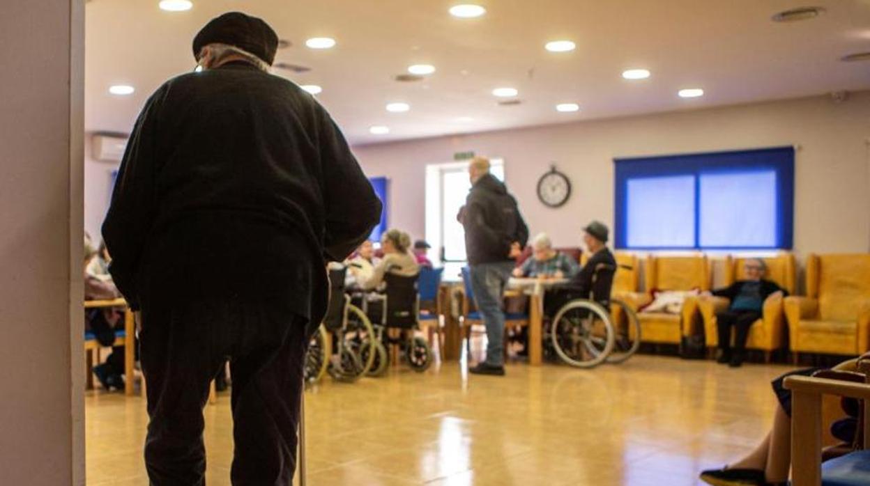 Un anciano entra en una sala común de una residencia de mayores