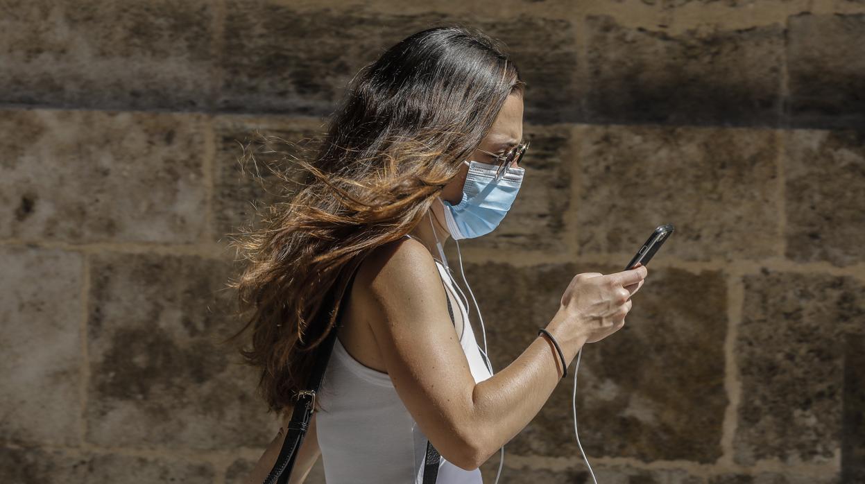 Imagen de una chica paseando por Valencia con mascarilla