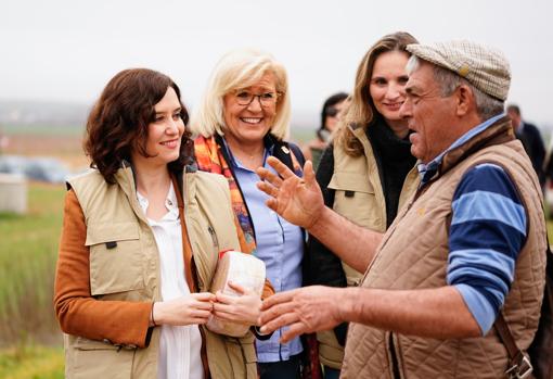 La presidenta de la Comunidad de Madrid, Isabel Díaz Ayuso, y la consejera de Medio Ambiente, Paloma Martín, conversando con un agricultor madrileño en una imagen de archivo