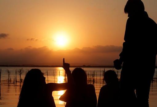 Varias personas disfrutan del atardecer en el parque natural valenciano