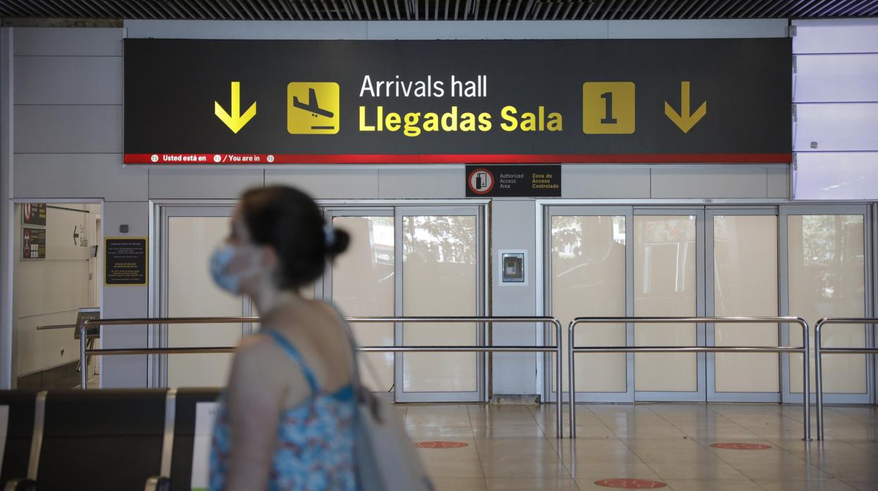 Pasajeros abandonan una de las salidas de la sala de llegadas de la Terminal 1 del Aeropuerto de Barajas, en Madrid