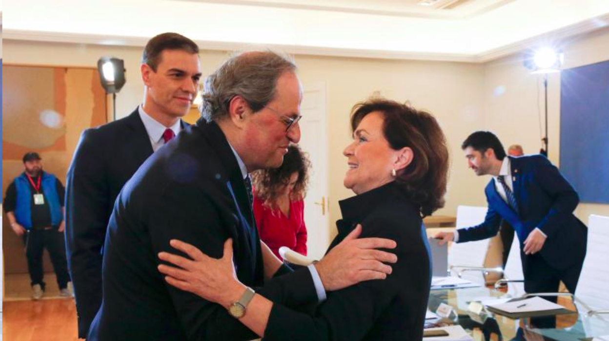 Quim Torra saluda a Carmen Calvo, ante la mirada de Pedro Sánchez, en La Moncloa, antes de la reunión de febrero de este año