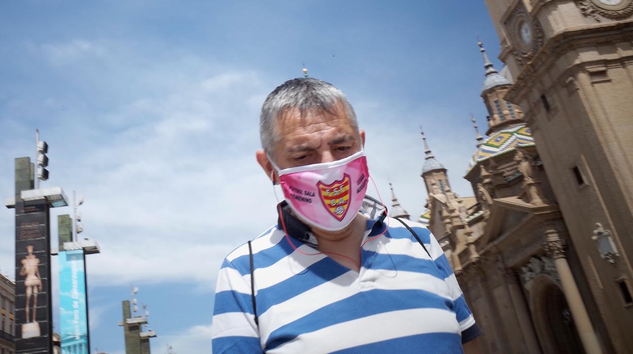 Un ciudadano caminando con mascarilla por la Plaza del Pilar de Zaragoza