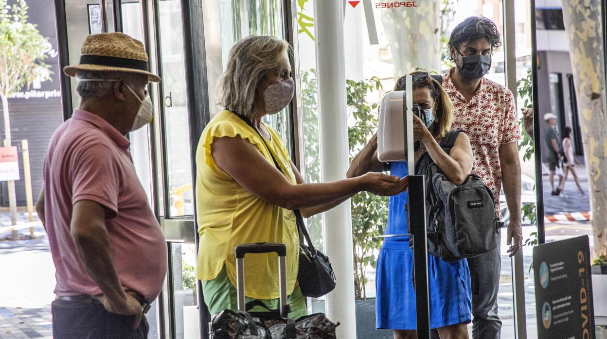 Imagen de turistas con mascarilla entrando en un hotel de Alicante