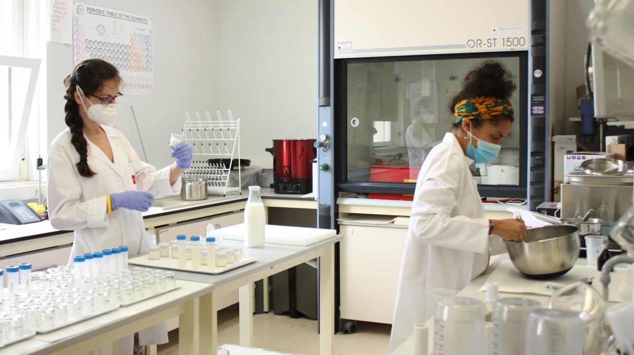 Dos investigadoras manipulan la leche en un laboratorio