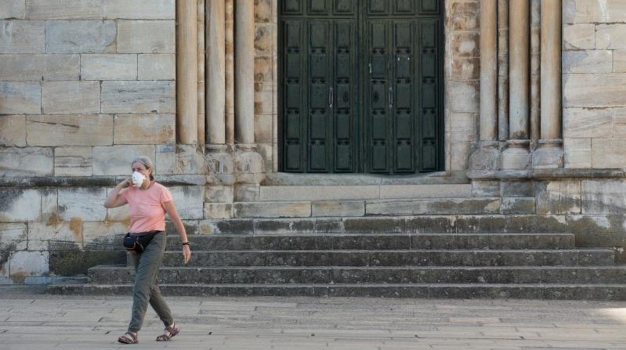 Una mujer, con mascarilla, en la localidad lucense de Portomarín