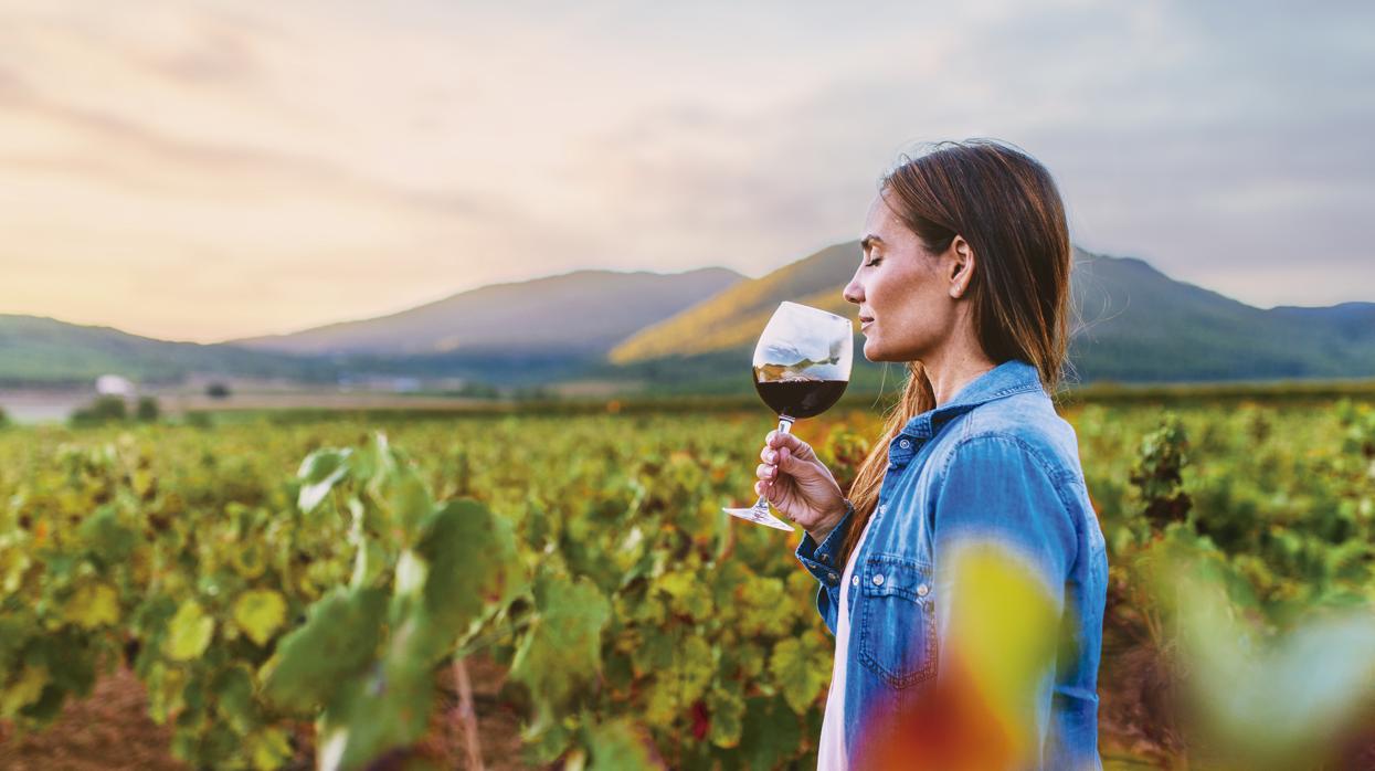 Una mujer cata una copa de vino tinto en uno de los viñedos de Castilla-La Mancha