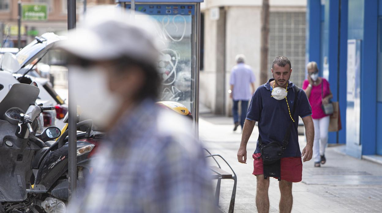 Imagen de viandantes con y sin mascarilla en Valencia