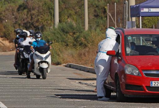 Imagen de un sanitario realizando la prueba del Covid-19 a una persona en su vehículo