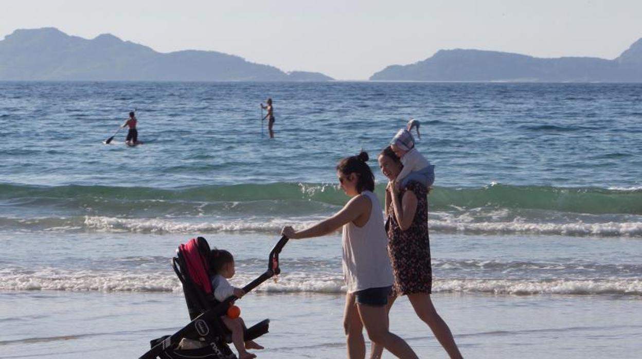 Personas paseando por la playa en Nigrán, en la ría de Vigo