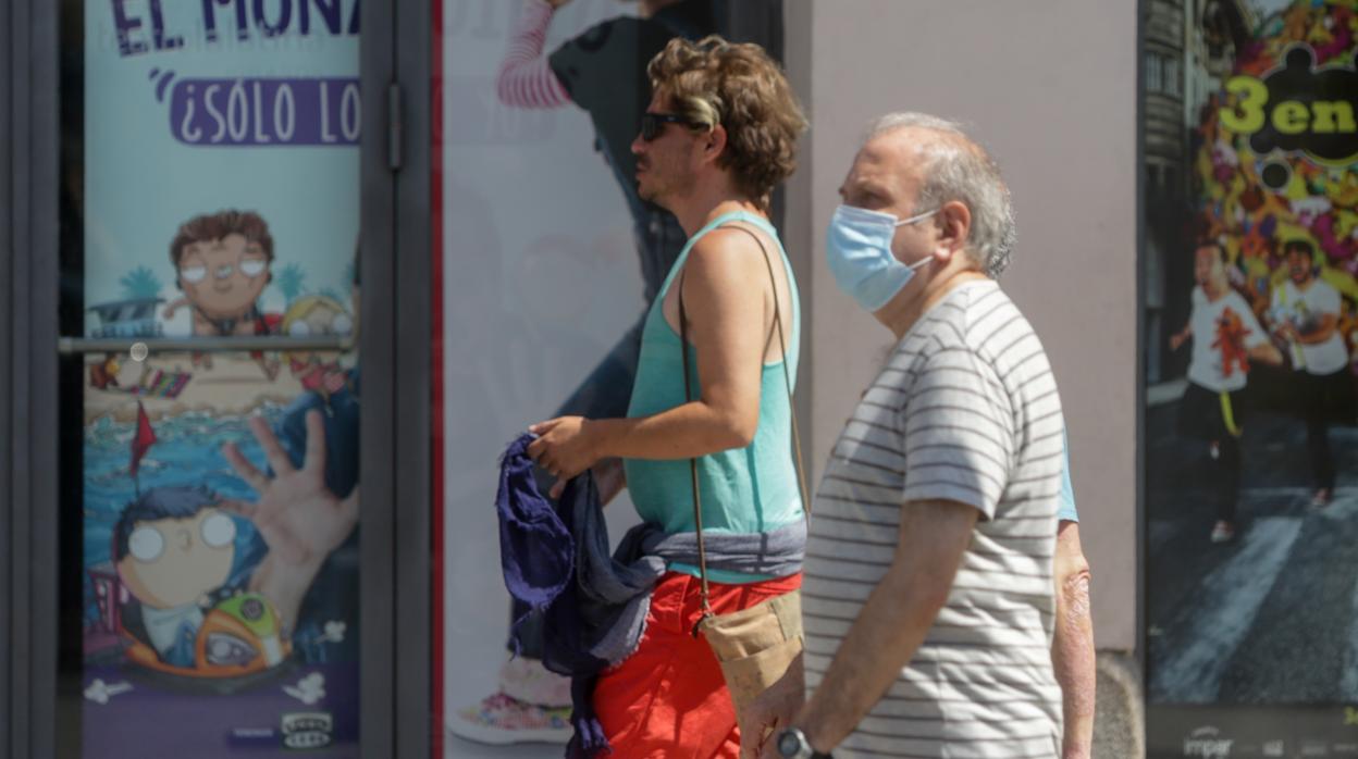 Transeúntes pasean por la capital, donde no es obligatorio el uso de mascarilla