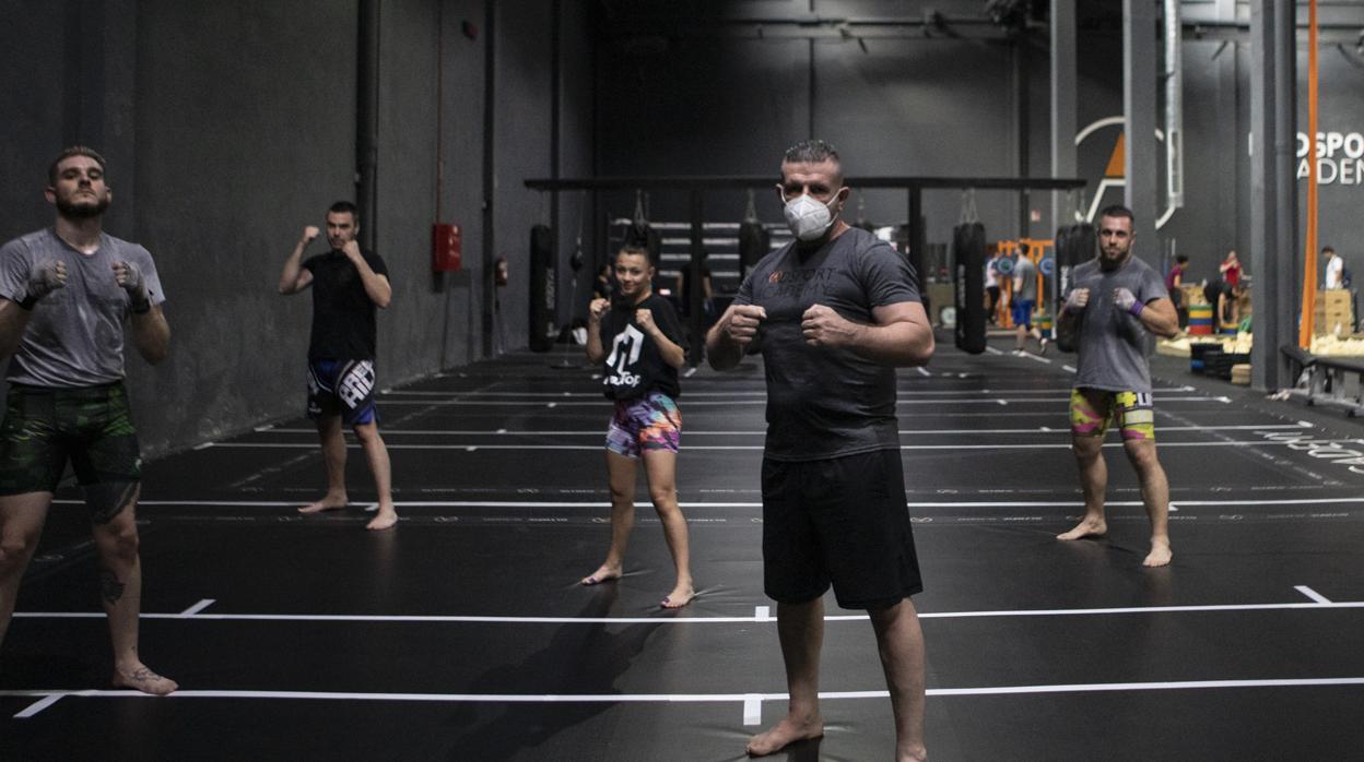 Varios practicantes de artes marciales mixtas guardan la distancia de seguridad en el MadSport Academy