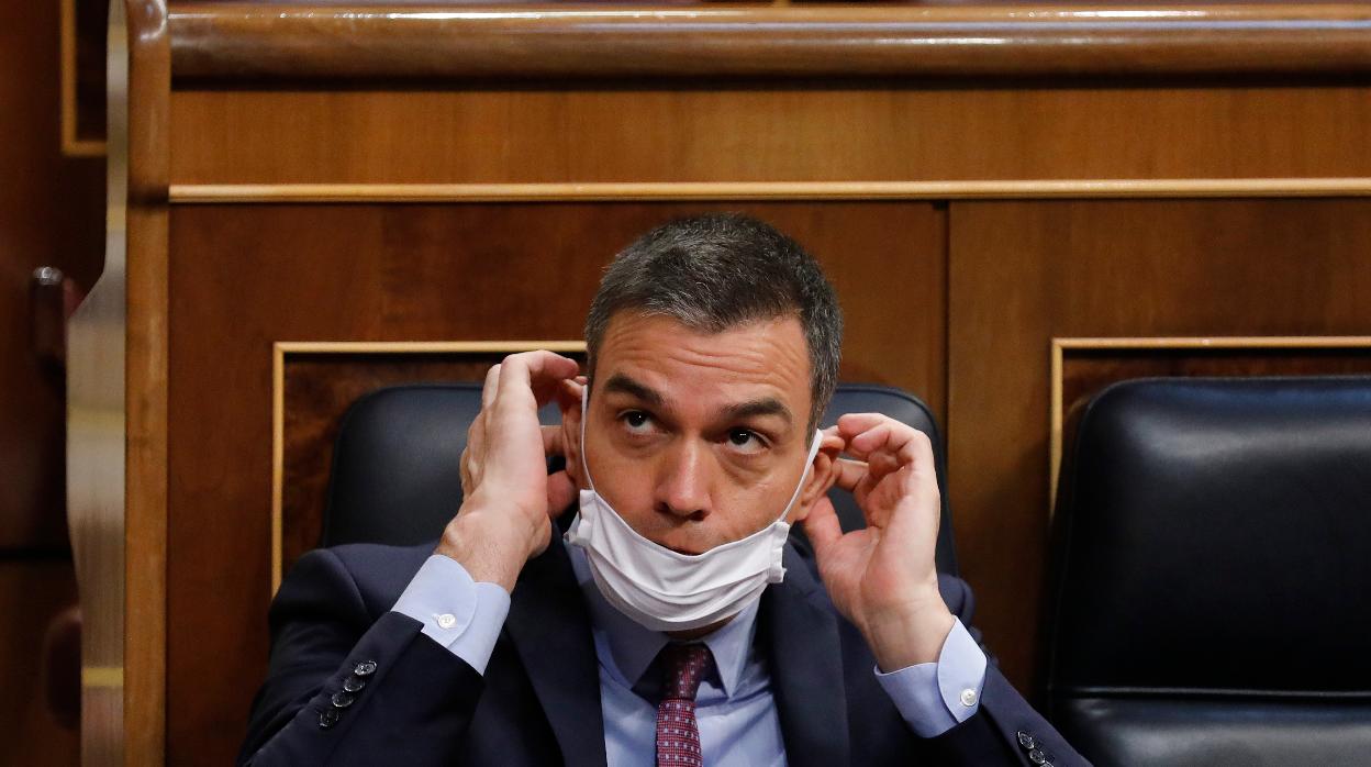 Sánchez se coloca la mascarilla en un pleno del Congreso