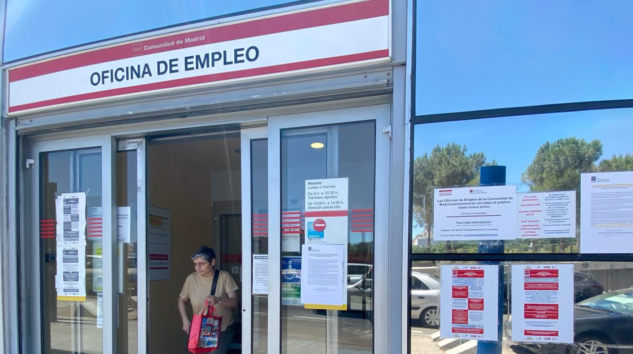 Una mujer sale por la puerta de una oficina del SEPE