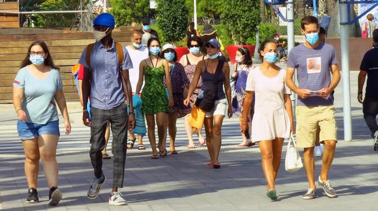 Transeúntes con mascarilla paseando por una calle de Alicante.