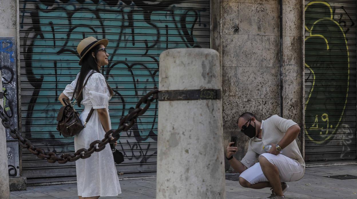 Dos turistas con mascarillas en las calles de Valencia durante este agosto