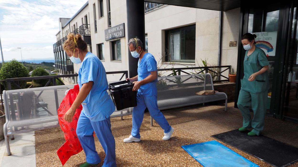 Trabajadores sanitarios salen de la residencia O Incio, en Lugo