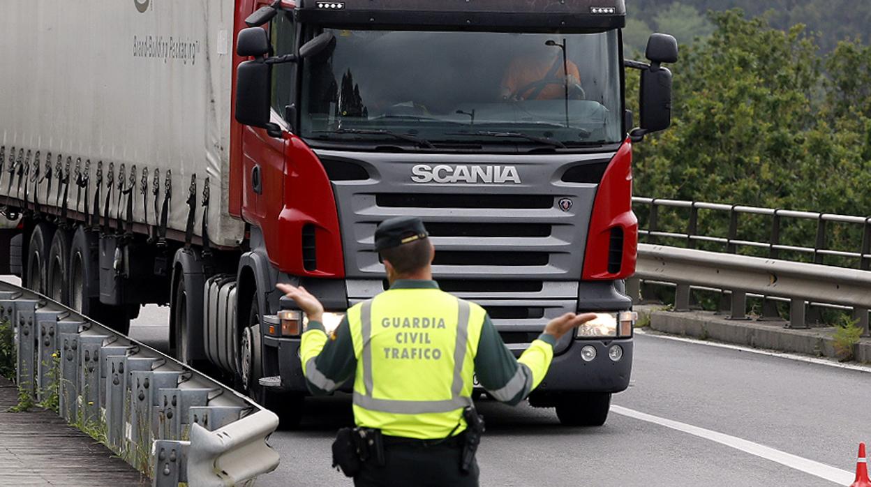 Un agente de la Guardia Civil para en la carretera a un camión