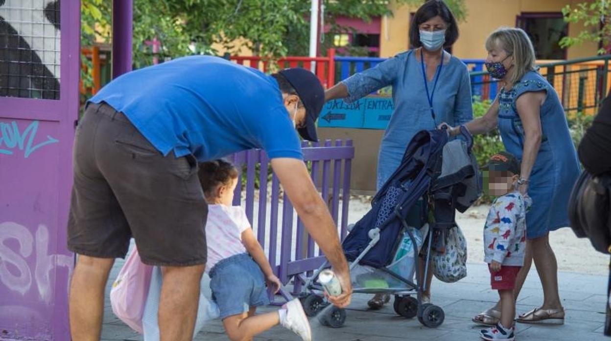 Padres desinfectando el calzado de los alumnos, a la entrada de la Escuela Infantil El Pilar, en la calle de Alcalá