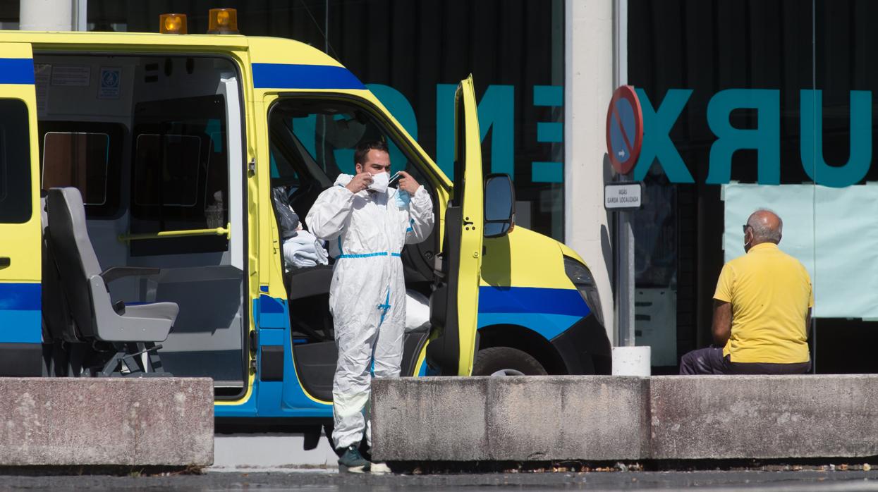 Un profesional sanitario baja de la ambulancia en la que viaja un paciente con Covid-19 que ha sido trasladado desde el Hospital de O Incio al Hospital de Lugo, el jueves