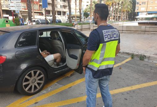 Un policía nacional junto un detenido en la operación