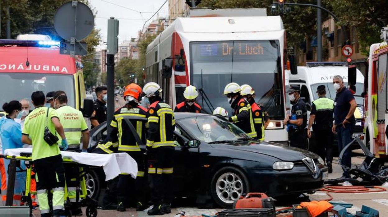 Personal de los servicios de emergencia en la excarcelación del vehículo, junto al tranvía tras el choque