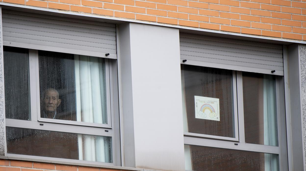 Un anciano mira por la ventana de una residencia en Madrid