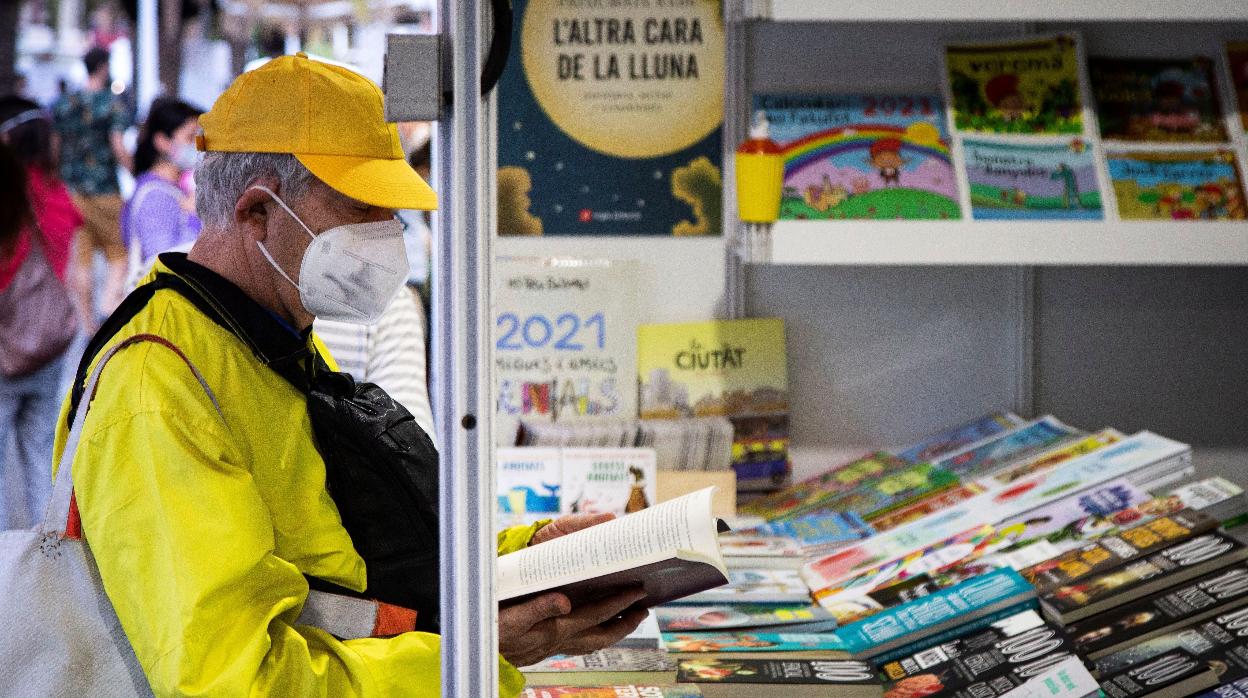 Un visitante hojea un libro en un tenderete de la Setmana del Llibre Català