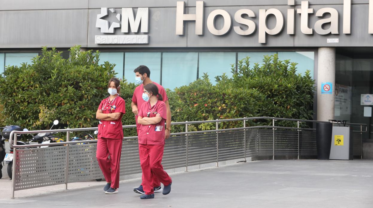 Tres sanitarios pasean por las inmediaciones de la puerta del Hospital de La Paz