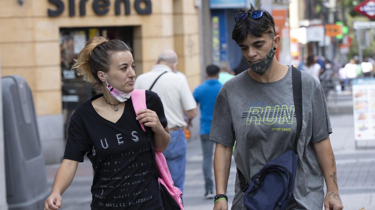 Dos viandantes junto al Metro de Nueva Numancia, en Puente de Vallecas