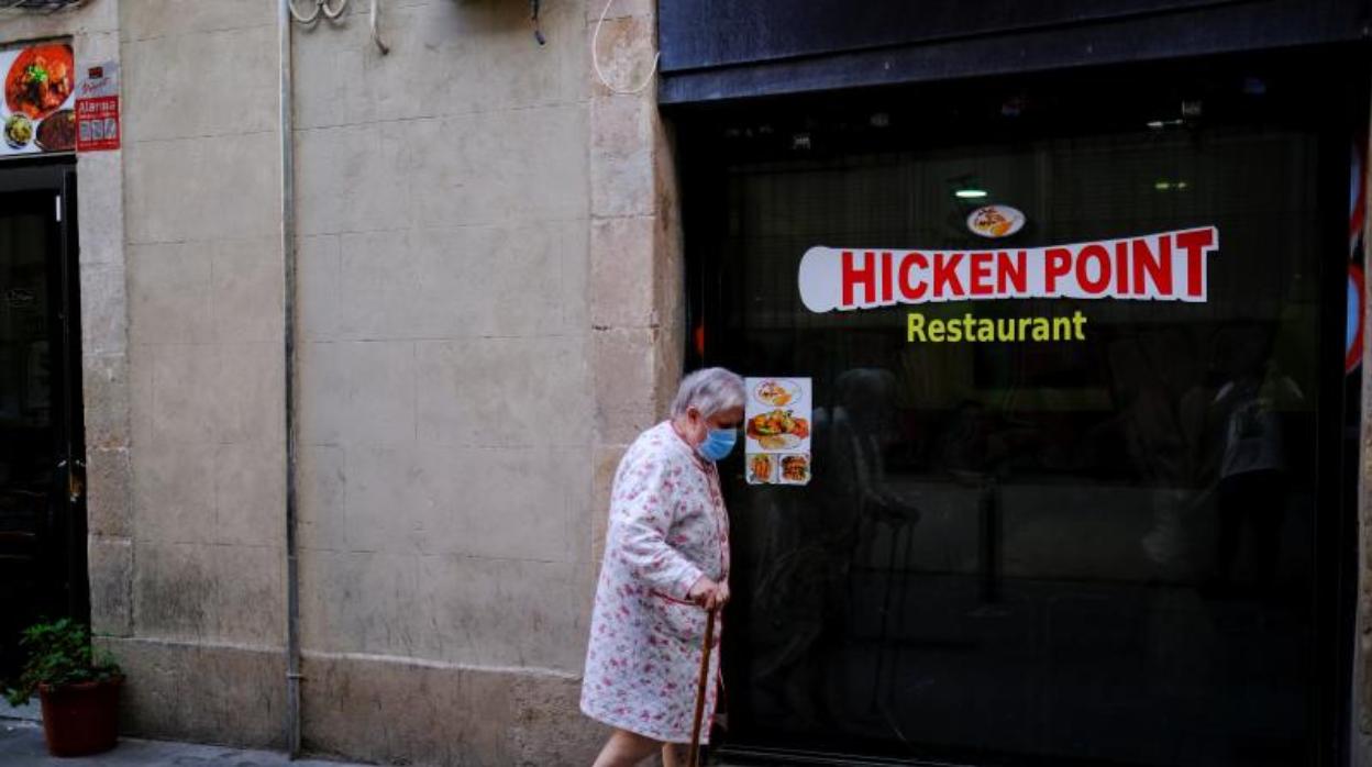 Una anciana pasea esta semana por el barrio del Raval de Barcelona