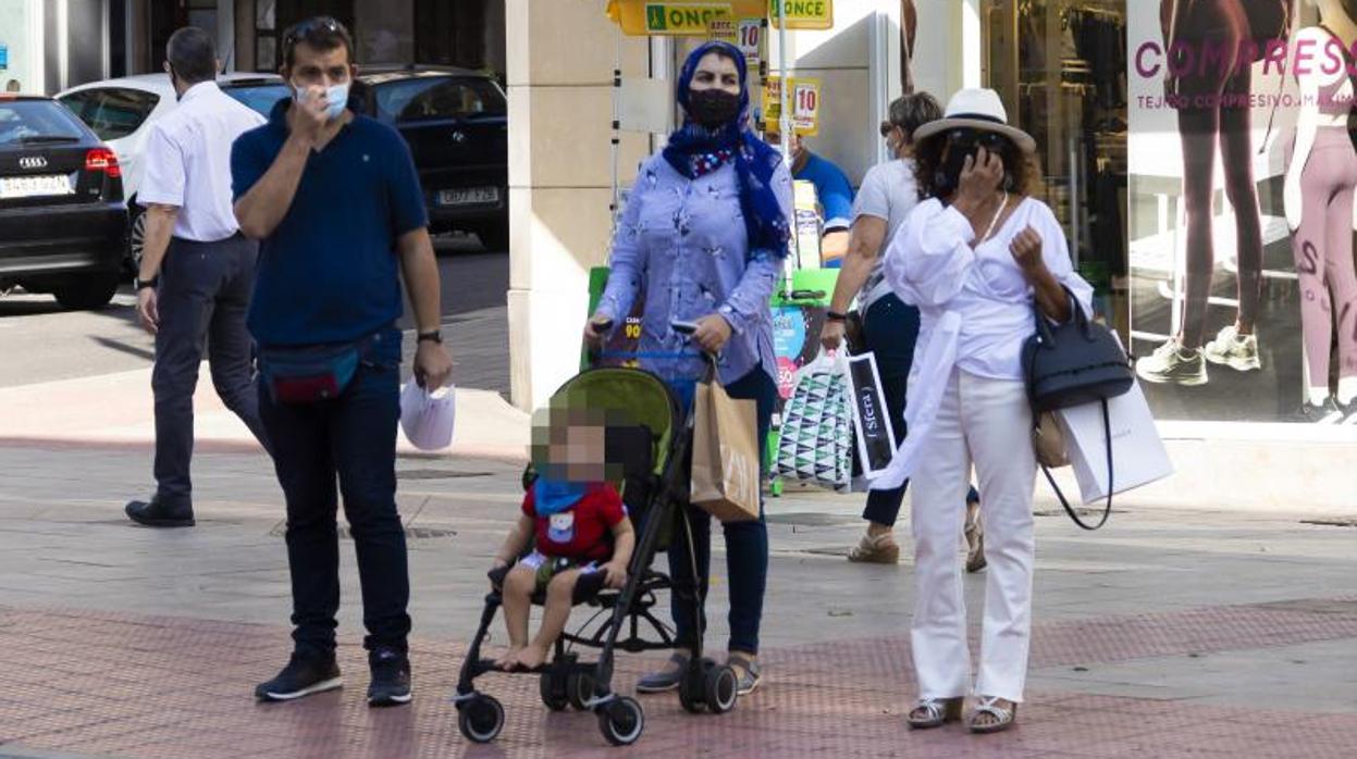 Transeúntes con mascarilla paseando por una calle en Alicante