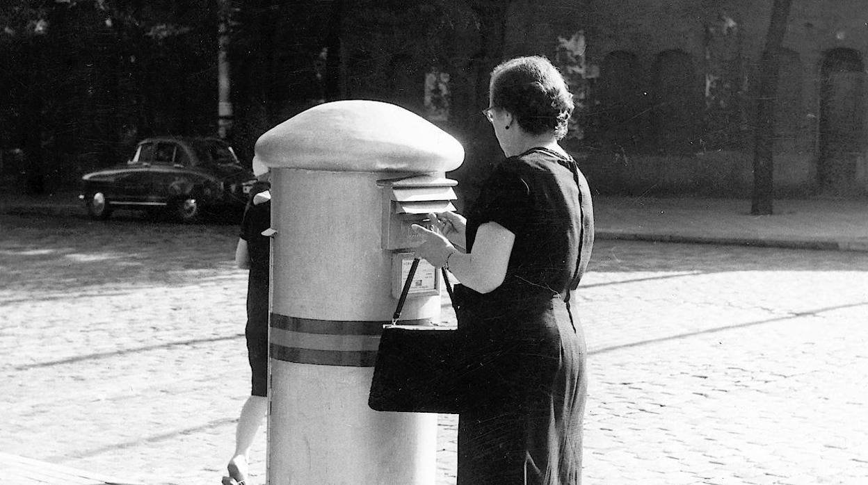 Una mujer deposita una carta en un buzón de Madrid, en 1962