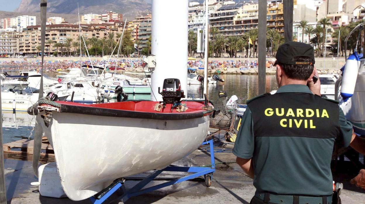 Imagen de archivo de un agente de la Guardia Civil junto a una patera detectada en Benidorm