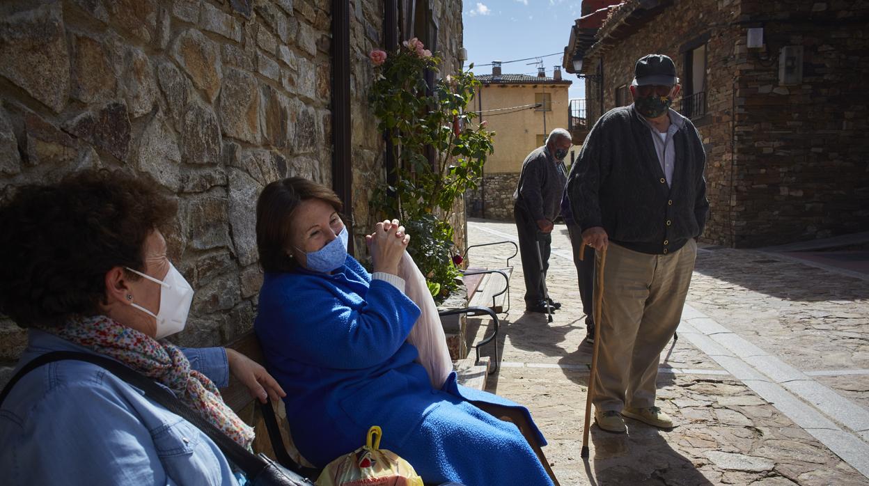 Pilar, Eugenio y María Dolores charlan frente a la plaza del Ayuntamiento de Puebla de la Sierra