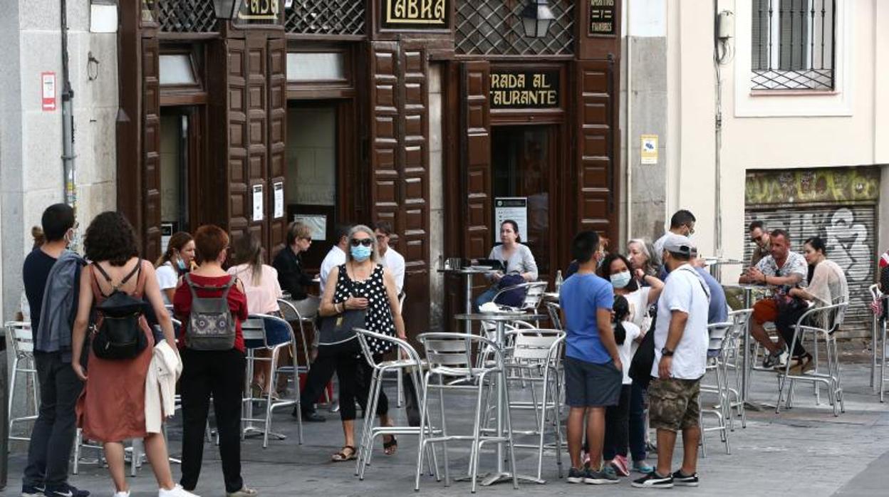 Clientes de un local de hostelería próximo a la Puerta del Sol, toman un aperitivo en su terraza