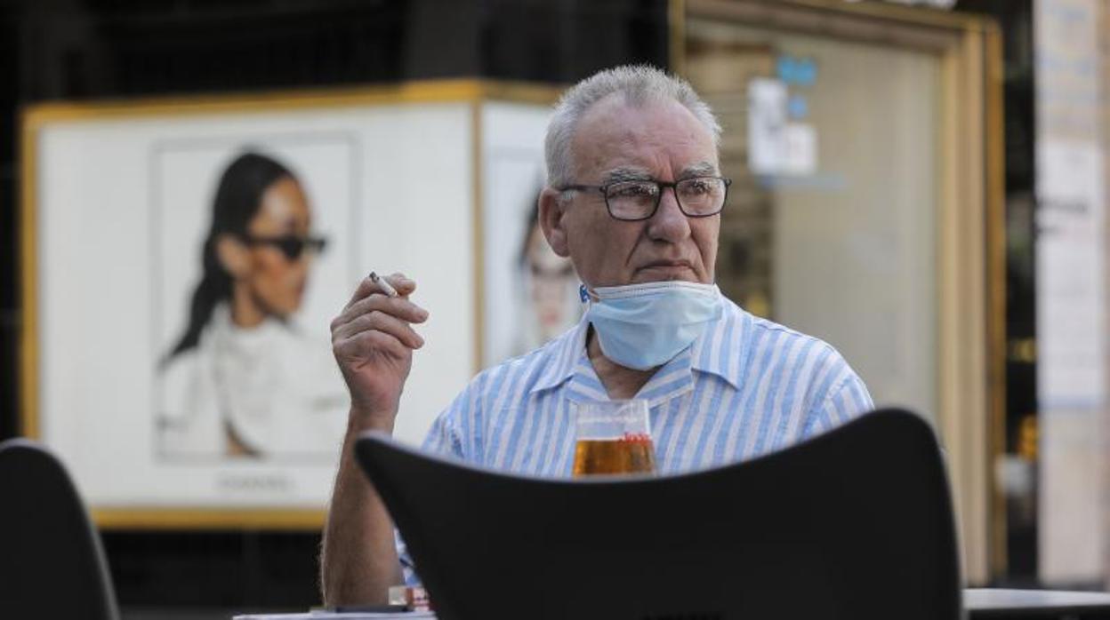 Un hombre fuma en la terraza de un bar en Valencia