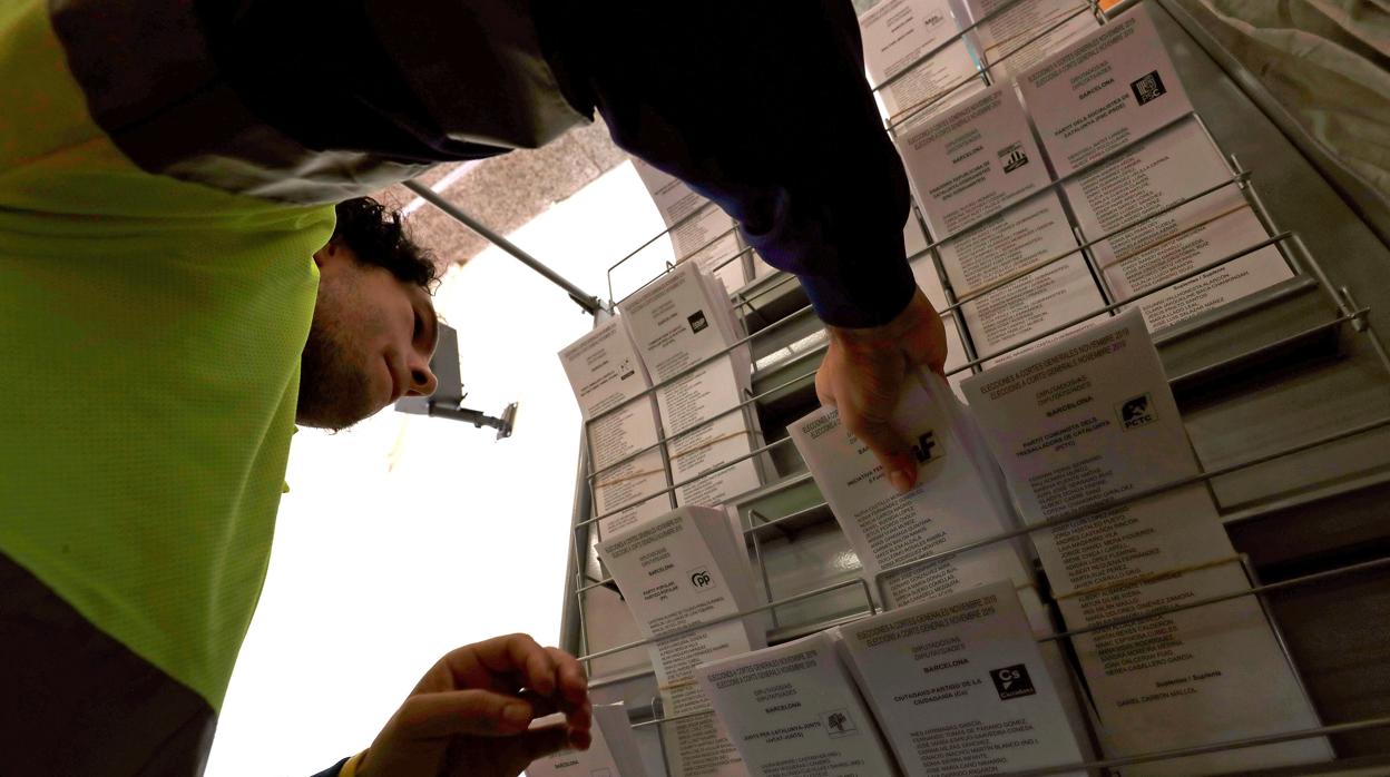 Un operario coloca papeletas electorales en un colegio de Barcelona