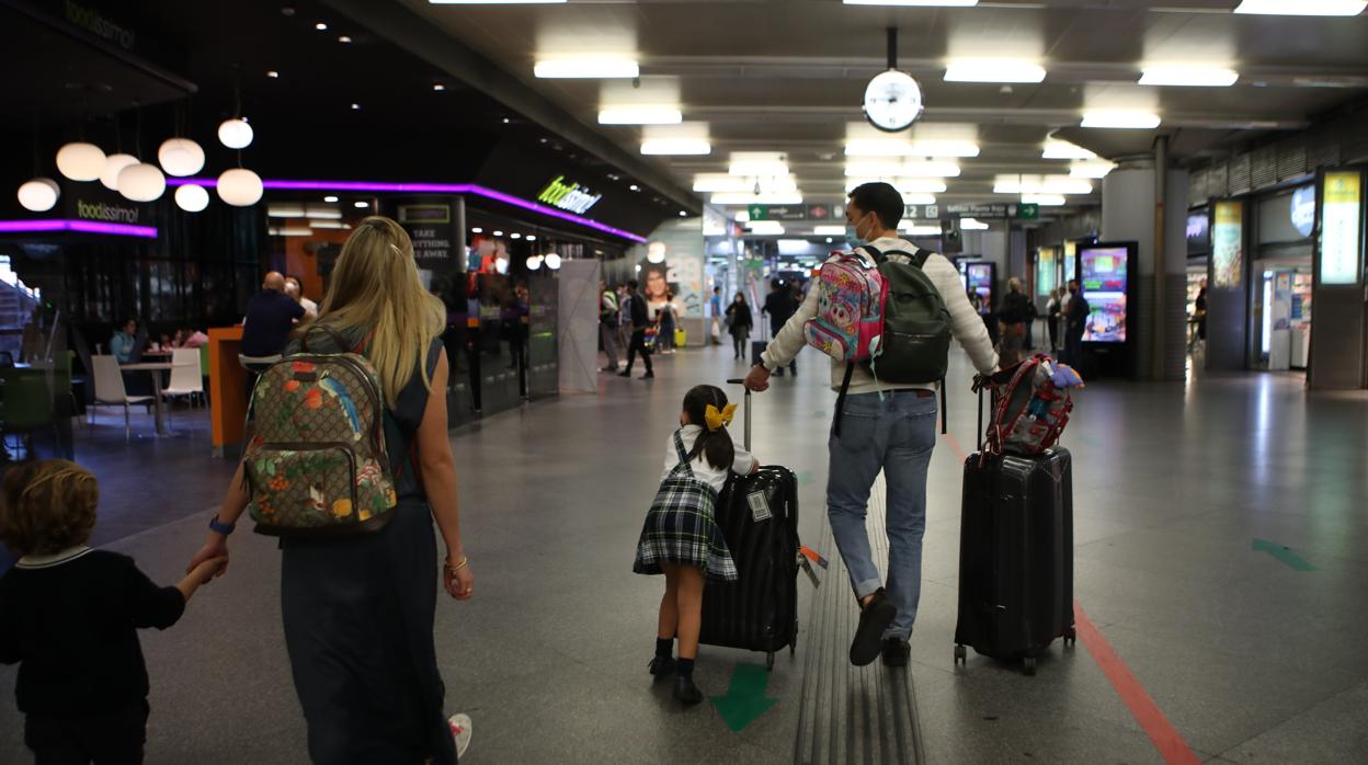 Una familia camina por la estación de Atocha con varias maletas